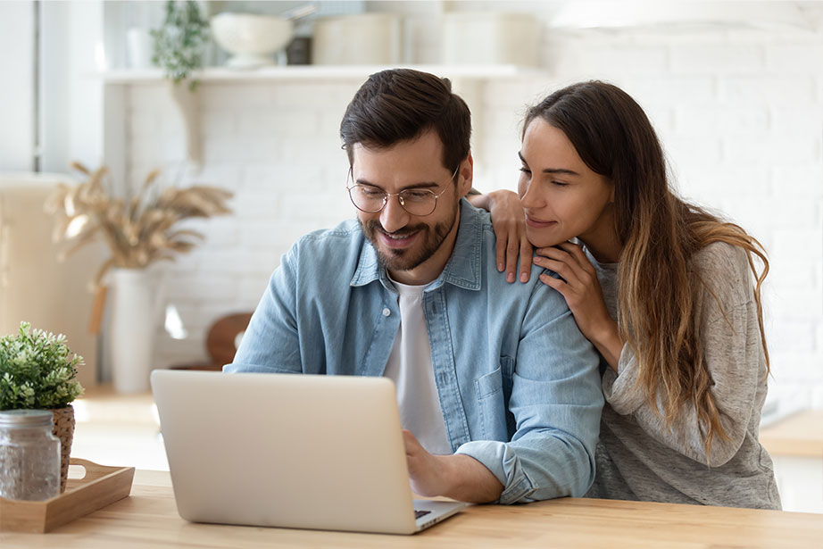 Photo of Couple Looking at a Laptop